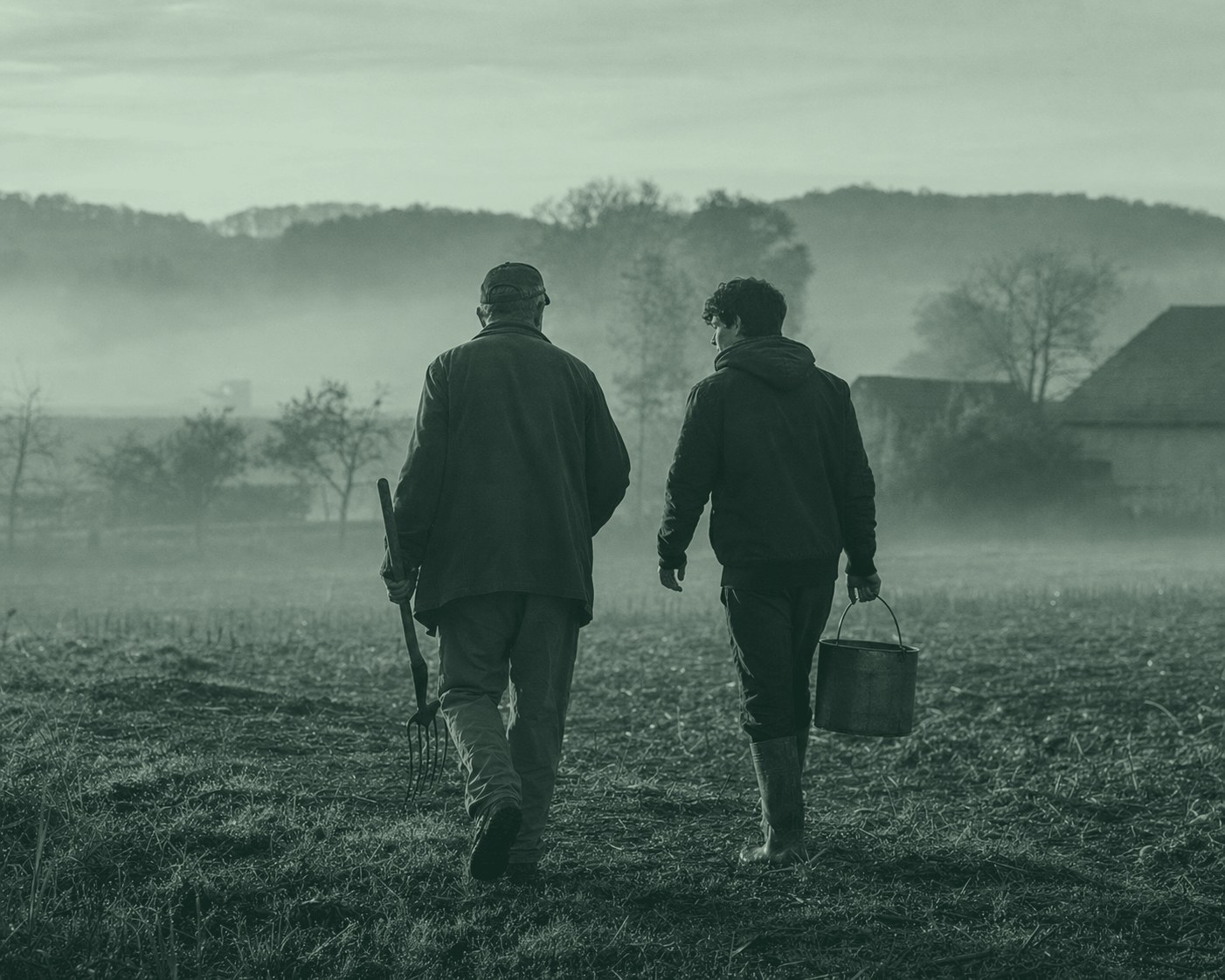 A farming family walking together across a field at dawn